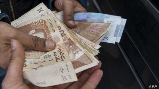 A man holds bills of Moroccan dirham on January 23, 2018 in Casablanca. - After years fighting to evict tenants he believes are backed by corrupt officials, Slimane Brihmi called a much-heralded anti-graft hotline in Morocco -- but it made no difference. Like many countries struggling with endemic corruption, the North African kingdom has launched various initiatives to tackle the phenomenon. (Photo by FADEL SENNA / AFP)